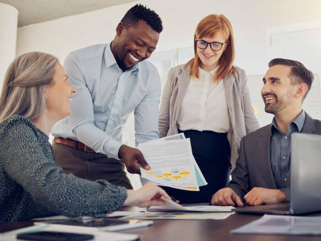 Team of colleagues reviewing documents together at a meeting