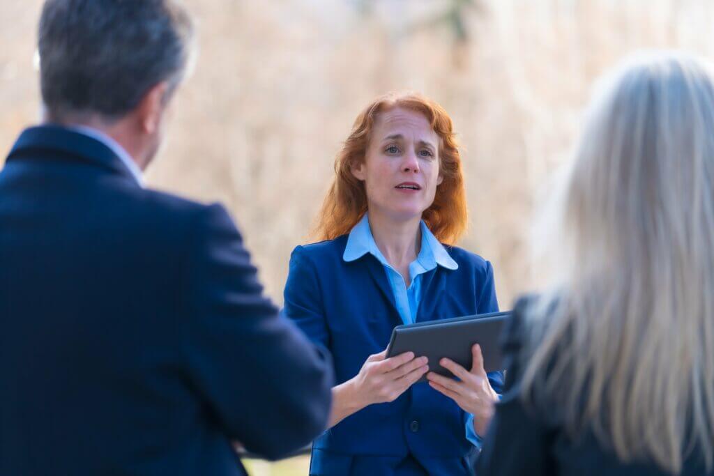 Professionals talking with a client holding a tablet